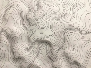 Topographical contour lines map on paper texture, photo