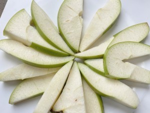 Crisp green apple slices arranged in a radial pattern, photo