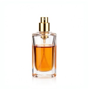 Transparent glass perfume bottle with amber liquid and gold spray nozzle