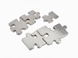 Interlocking metal puzzle pieces made of brushed steel, floating in isolation, photo