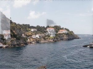 Body of water near buildings on cliff, photo