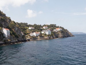 Body of water near buildings on cliff, photo