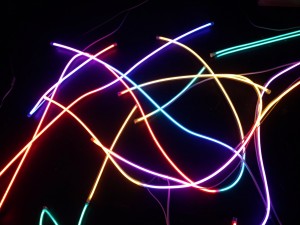 Neon tube lights arranged in abstract curves emitting colorful glow